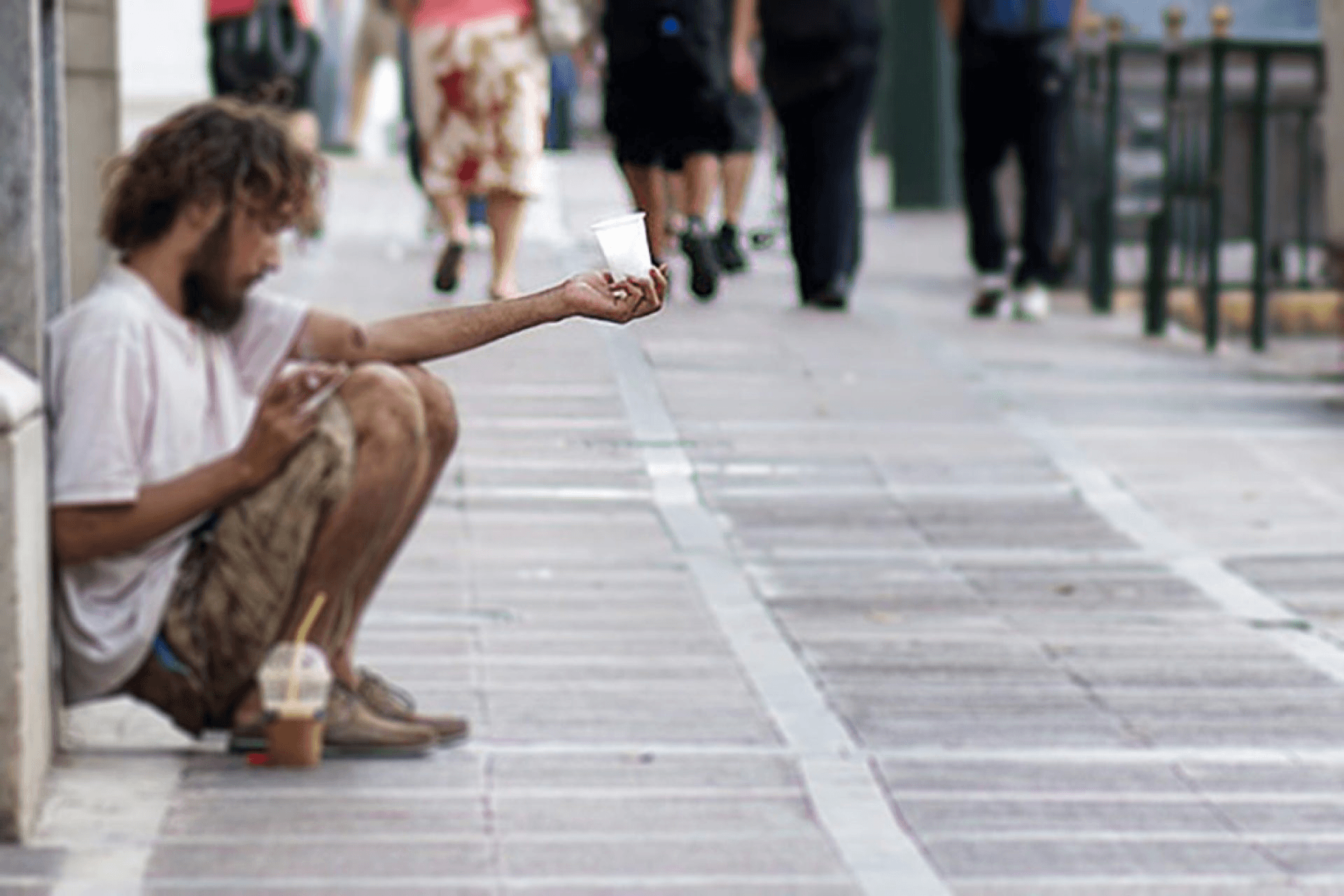 Europa, giovani e poveri: un ragazzo chiede l'elemosina a bordo strada