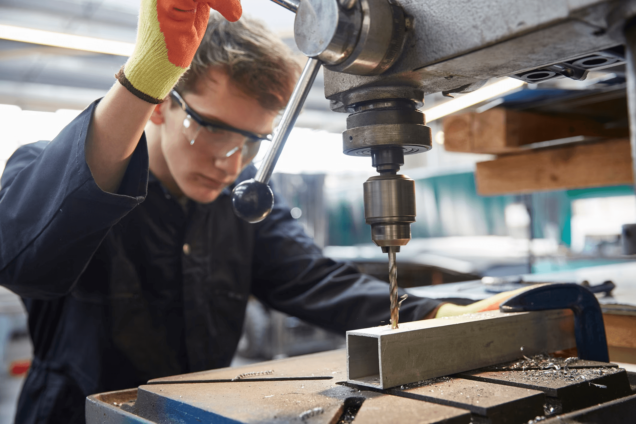 PCTO, è lavoro? Un minore in tuta all'opera in una fabbrica