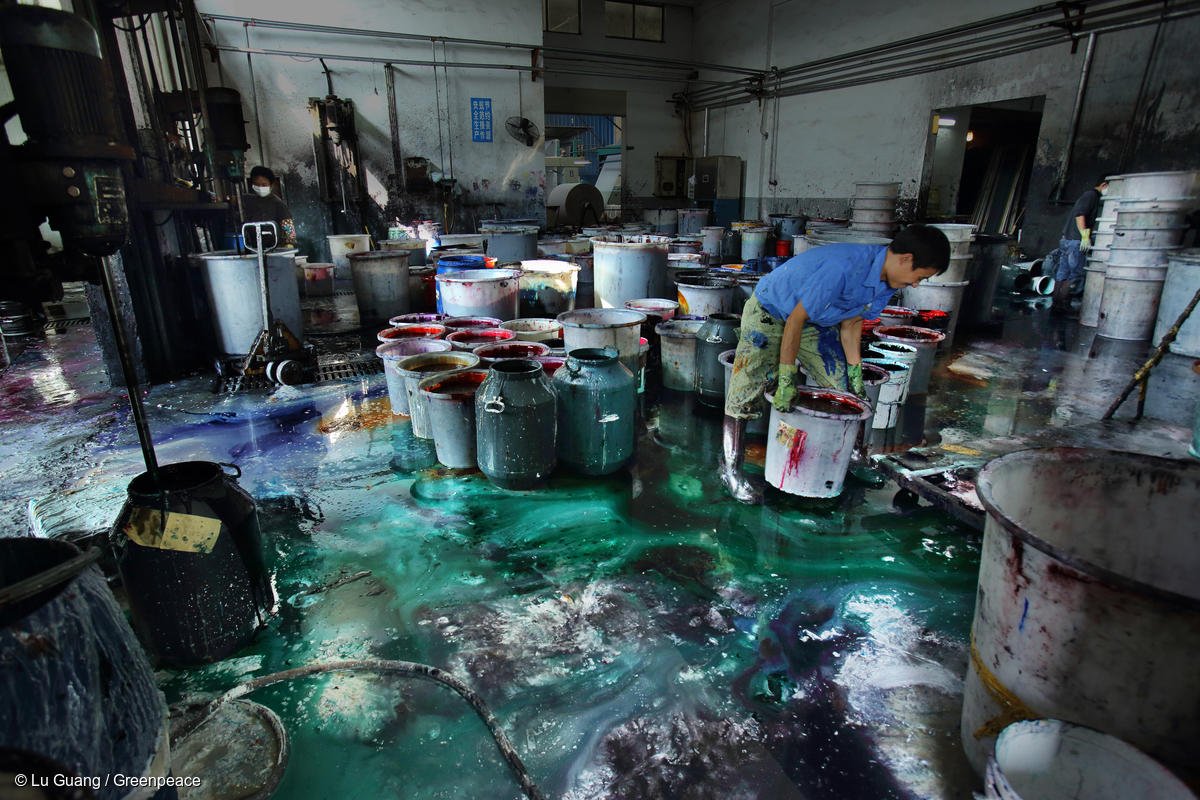 Un lavoratore asiatico in mezzo a coloranti tossici senza alcuna protezione