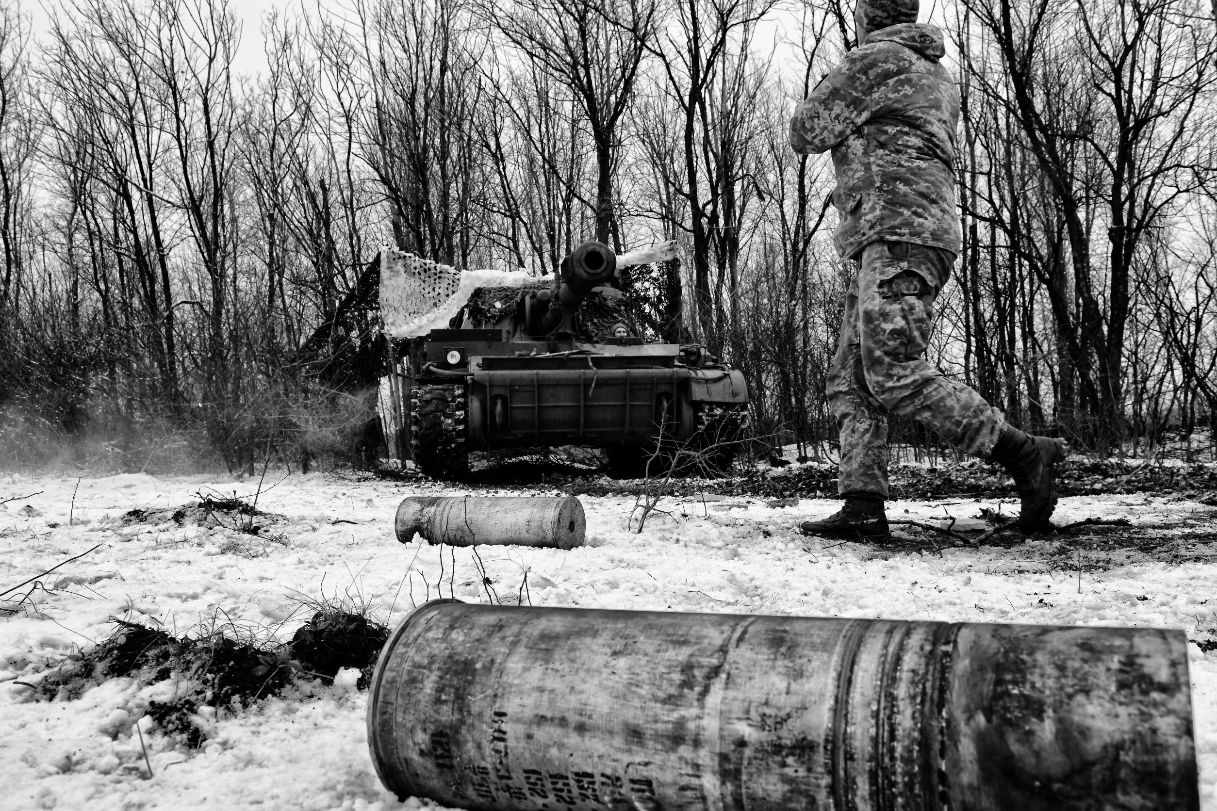 Guerra in Ucraina: un soldato cammina davanti a un carro armato, sulla neve