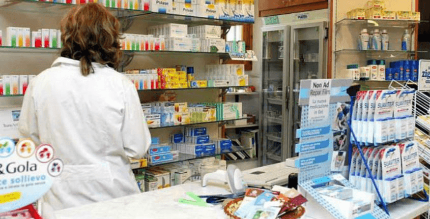 Farmacisti collaboratori, una farmacista di spalle al bancone