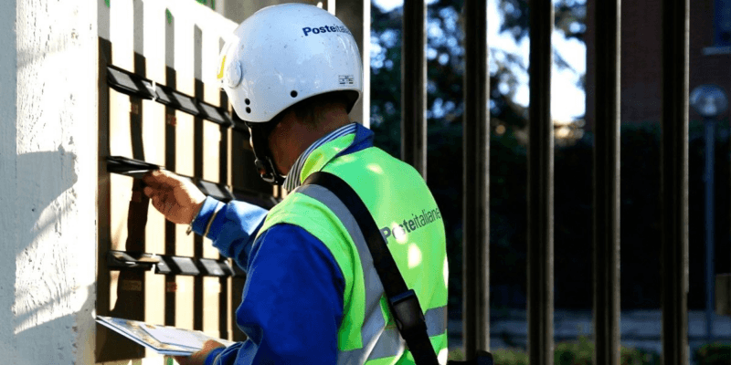 Un postino di Poste Italiane durante la consegna