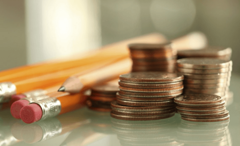 Alfabetizzazione finanziaria: una pila di monete accanto a delle matite