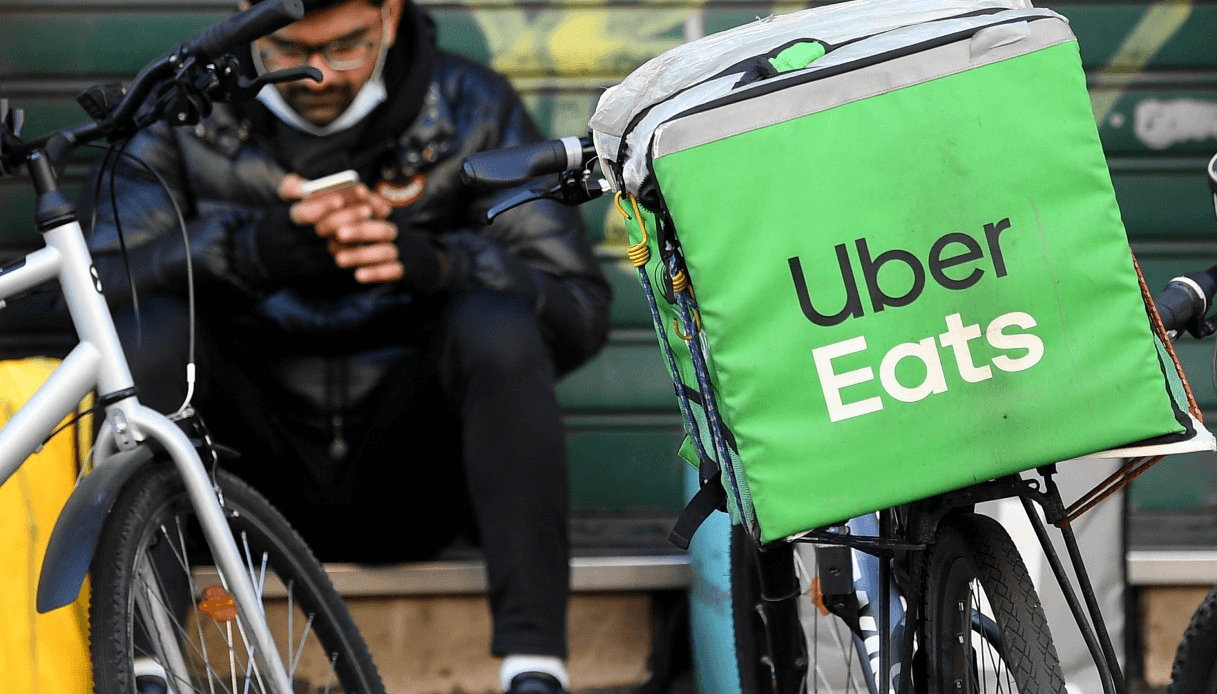 Un rider di Uber Eats licenziato dall'azienda, seduto su una panchina
