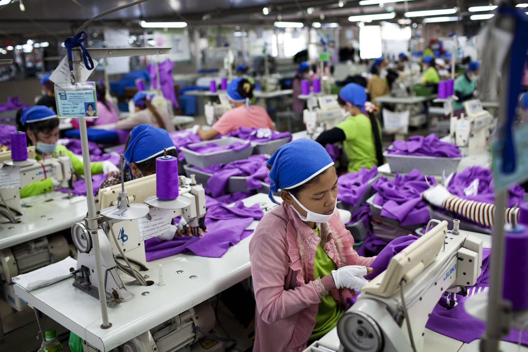 Divario di genere in azione nel settore tessile: una stanza piena di lavoratrici alla macchina da cucire, in Cambogia