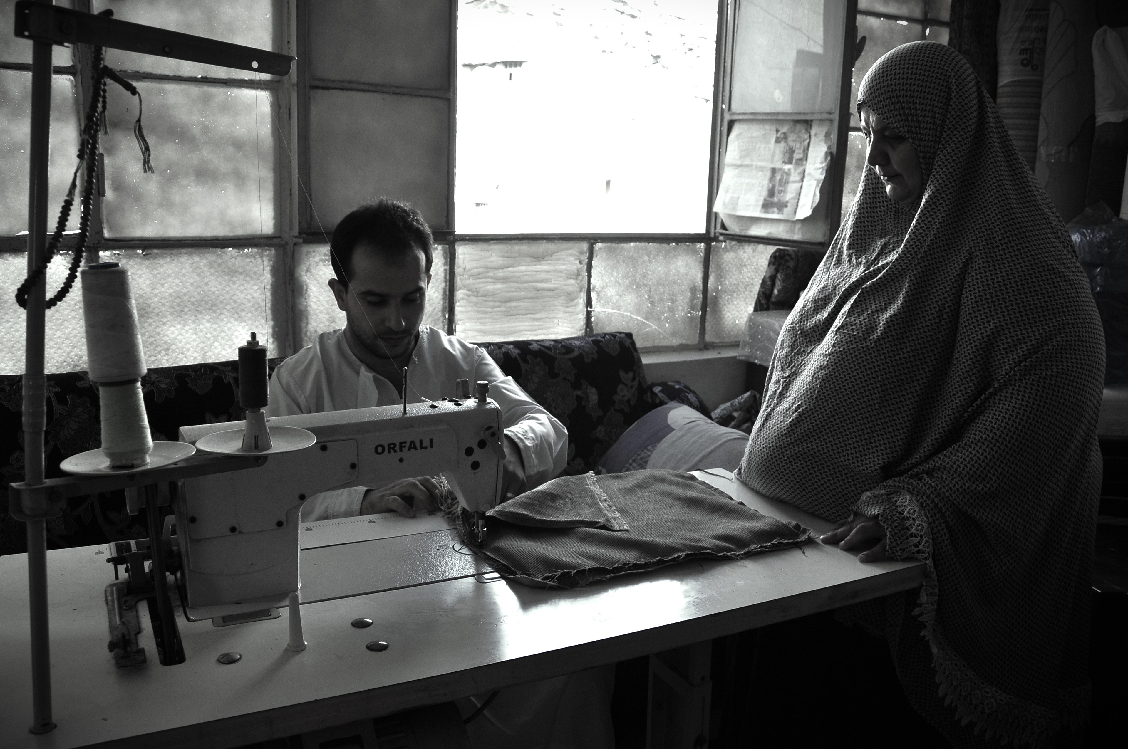 Dei profughi siriani sfruttati nel settore tessile lavorano alla macchina da cucito